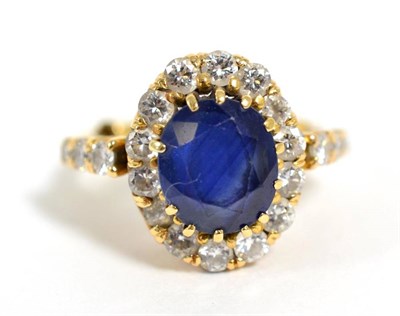 Lot 308 - A sapphire and diamond cluster ring, total estimated diamond weight 0.95 carat approximately,...