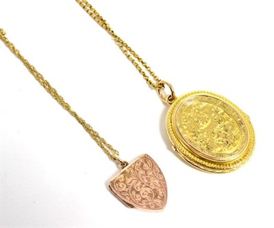 Lot 319 - A cased oval locket pendant, on chain and a chased shield-shaped locket pendant on chain, 19.1g...