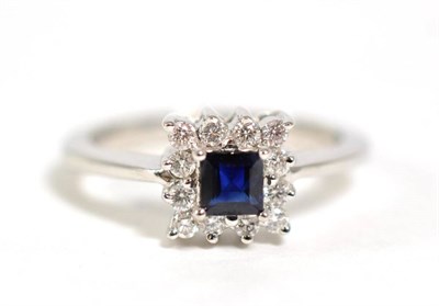 Lot 334 - A sapphire and diamond cluster ring, total estimated diamond weight 0.15 carat approximately,...