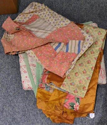 Lot 1055 - A circa 1930/40s patchwork bed cover, with pink cotton floral mount bordering blue and yellow...