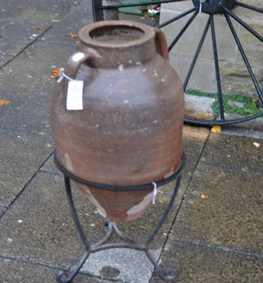 Lot 1368 - A terracotta oil jar on metal stand