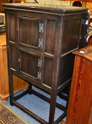 Lot 1386 - An oak cupboard on stand