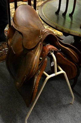 Lot 1433 - A leather saddle by Swaine Adeney; and an early 20th century cavalry officers saddle, with...