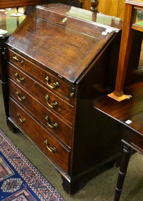 Lot 1510 - George III oak bureau with four graduated drawers on bracket feet (good colour)