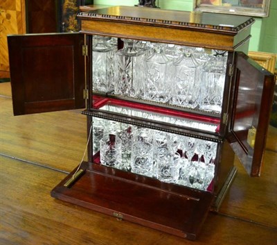 Lot 1542 - A mahogany table top cocktail cabinet containing four decanters, six whisky tumblers and six sherry