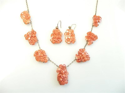 Lot 287 - A Carved Coral Necklace with Matching Earrings, the panels carved with floral motifs, in claw...