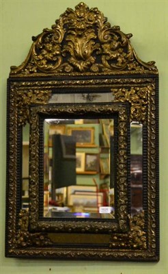 Lot 1626 - Ebonised and gilt metal repousse decorated marginal mirror