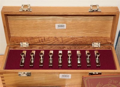 Lot 3060 - A Set of Nine Stainless Steel Hip Flasks, inscribed Peg 1 to Peg 9, in a wooden box (as new)