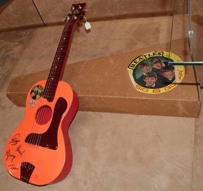 Lot 3348 - Selco Beatles Guitar orange plastic with faux signatures 32'', 81cm (G but lacks some of...