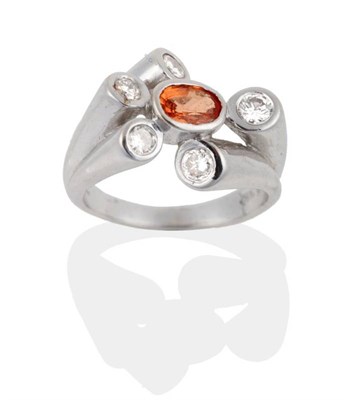 Lot 2013 - An Orange Sapphire and Diamond Ring, an oval cut orange sapphire in a rubbed over setting spaced by
