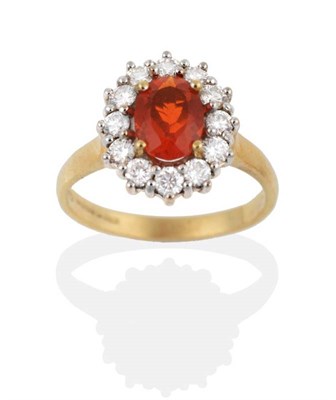 Lot 2015 - An 18 Carat Gold Fire Opal and Diamond Cluster Ring, an oval cut fire opal within a border of round