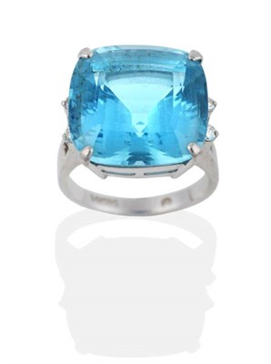 Lot 2023 - A Blue Topaz and Diamond Ring, a mixed cushion cut blue topaz in a claw setting and spaced by pairs