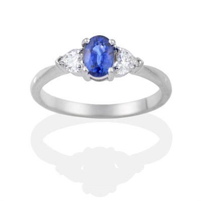 Lot 2035 - An 18 Carat White Gold Sapphire and Diamond Three Stone Ring, an oval cut sapphire spaced by...