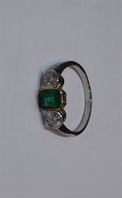 Lot 2041 - An Emerald and Diamond Three Stone Ring, a grain set octagonal cut emerald spaced by round...