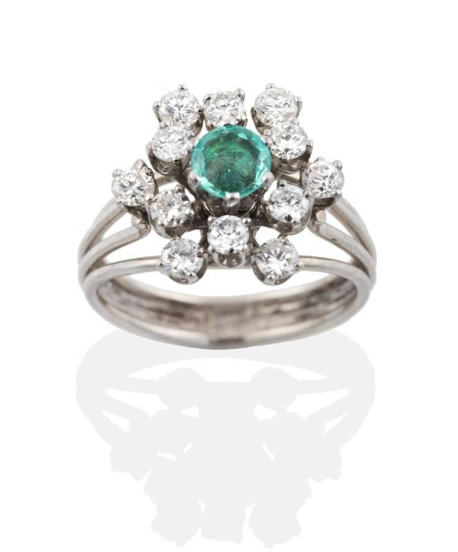 Lot 2053 - An Emerald and Diamond Cluster Ring, a round cut emerald within a two tier border of round...