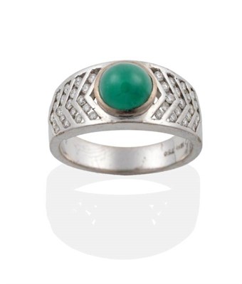 Lot 2054 - An Emerald and Diamond Ring, an oval cabochon emerald in a rubbed over setting, to tapering channel