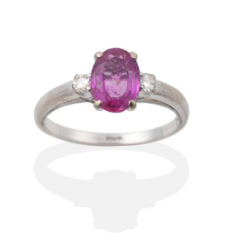Lot 2055 - A Ruby and Diamond Three Stone Ring, an oval cut ruby spaced by round brilliant cut diamonds, total