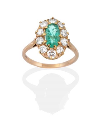 Lot 2095 - An Emerald and Diamond Cluster Ring, an oval cut emerald within a border of round brilliant cut...