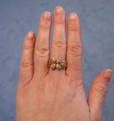 Lot 2103 - An 18 Carat Gold Diamond Ring, four old cut diamonds in claw settings within a scroll motif, to...