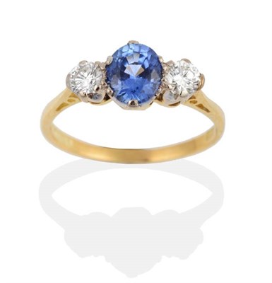 Lot 2114 - An 18 Carat Gold Sapphire and Diamond Three Stone Ring, an oval cut sapphire spaced by round...