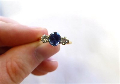 Lot 2114 - An 18 Carat Gold Sapphire and Diamond Three Stone Ring, an oval cut sapphire spaced by round...