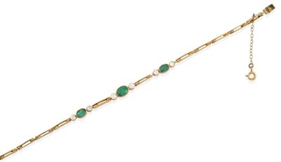 Lot 2116 - An Emerald and Diamond Bracelet, three graduated oval cut emeralds spaced by round brilliant...