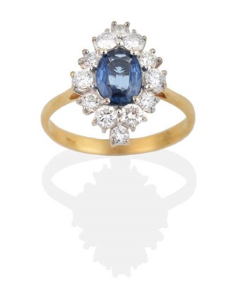 Lot 2117 - An 18 Carat Gold Sapphire and Diamond Navette Cluster Ring, an oval cut sapphire within a border of