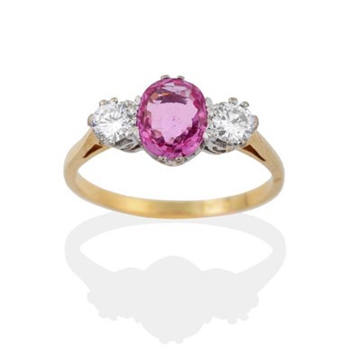 Lot 2151 - A Pink Sapphire and Diamond Three Stone Ring, an oval cut pink sapphire spaced by round...