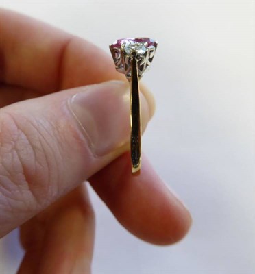 Lot 2151 - A Pink Sapphire and Diamond Three Stone Ring, an oval cut pink sapphire spaced by round...