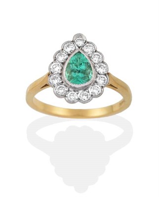 Lot 2152 - An 18 Carat Gold Emerald and Diamond Cluster Ring, a grain set pear cut emerald within a border...