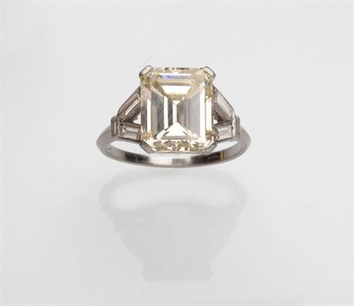 Lot 375 - An Emerald Cut Diamond Solitaire Ring, the central diamond in a white four claw setting to...
