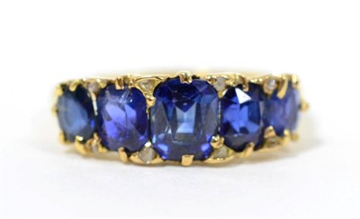 Lot 51 - A sapphire ring, five graduated oval cut sapphires spaced by rose cut diamond accents, finger...