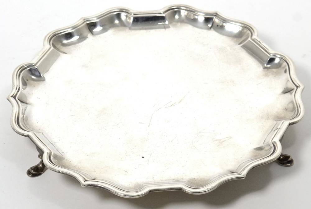 Lot 95 - A small circular silver salver, C S Harris & Son, London 1923, with shaped rim, on pad feet, 20.5cm