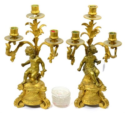 Lot 120 - A pair of French gilt bronze figural three-light candelabra, late 19th century, with leaf...
