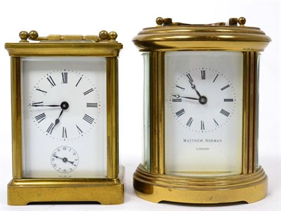 Lot 254 - An oval brass carriage clock, retailed by Matthew Norman London; and another carriage clock...