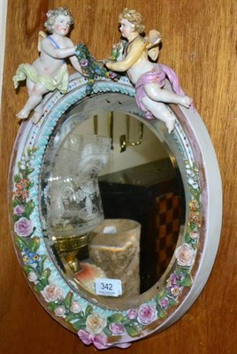 Lot 342 - A German porcelain oval wall mirror with putto surmount (restoration)