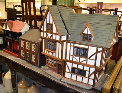 Lot 1123 - Two pre-war vintage dolls houses and another, half timbered example, dated (19)94 to underside (3)