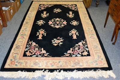 Lot 1258 - Chinese rug, the charcoal floral field enclosed by cream borders, 244cm by 152cm