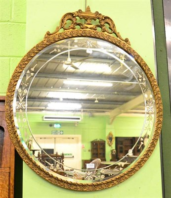 Lot 1335 - An early 20th century gilt and gesso circular mirror with floral engraved border