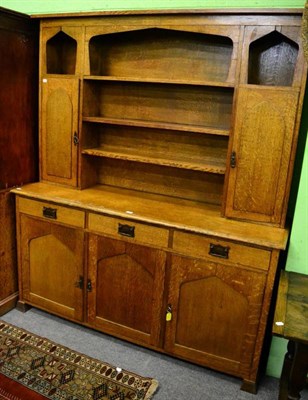 Lot 1336 - An English oak dresser, circa 1900, the rack with arched cupboard doors, the base with three...