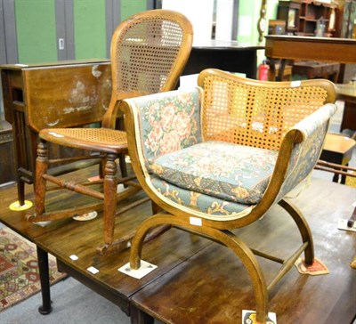 Lot 1366 - A walnut and satinwood banded Sutherland table, cane seated rocking chair and a cane back...