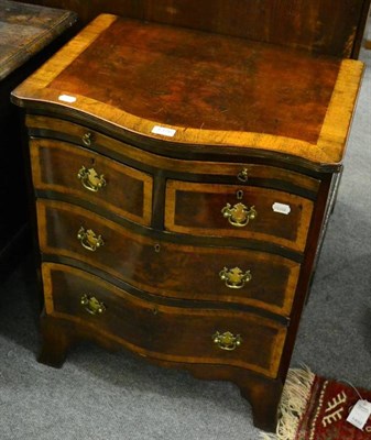 Lot 1376 - A small bow front crossbanded three height chest of drawers with dressing slide