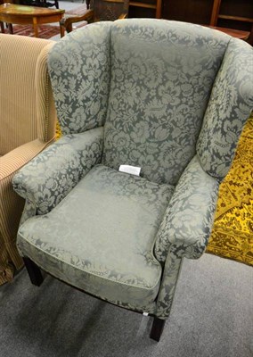 Lot 1388 - A George III style upholstered wing back armchair