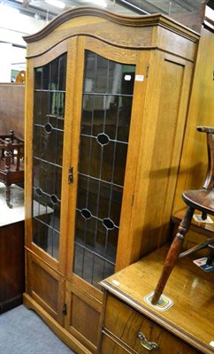 Lot 1438 - An early 20th century oak leaded glass door bookcase