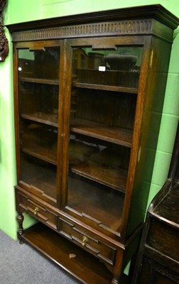 Lot 1460 - A glazed oak bookcase on stand