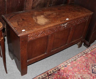 Lot 1479 - A panelled oak coffer with carved frieze