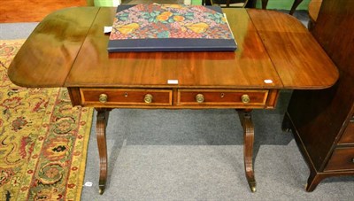 Lot 1486 - A mahogany sofa table on reeded supports, fitted with two drawers