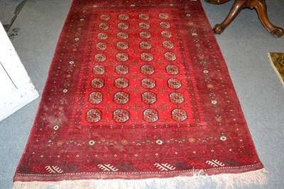 Lot 1492 - Turkmen rug North Afghanistan, the crimson field with four rows of guls enclosed by multiple...