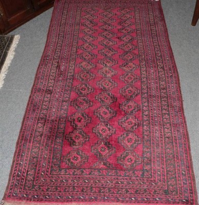 Lot 1496 - Turkmen rug North West Afghanistan, the claret field with three rows of guls enclosed by...