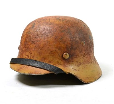 Lot 265 - A German Army M40 Combat Helmet, with later desert camouflage type paint, no decals, rolled...